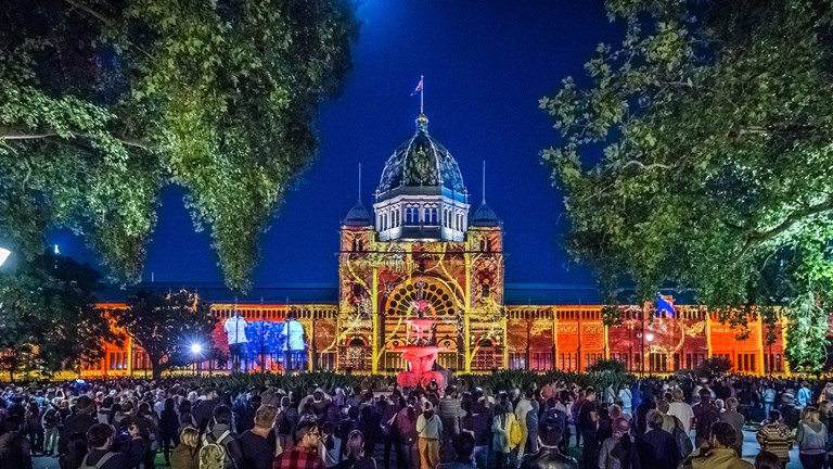 Crowd watching light projection on building