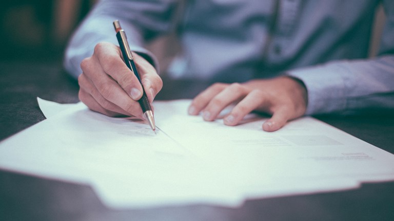 Close-up of a man's hand writing